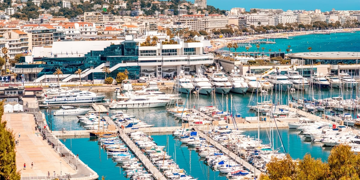 Driver opening door of luxury sedan in Cannes